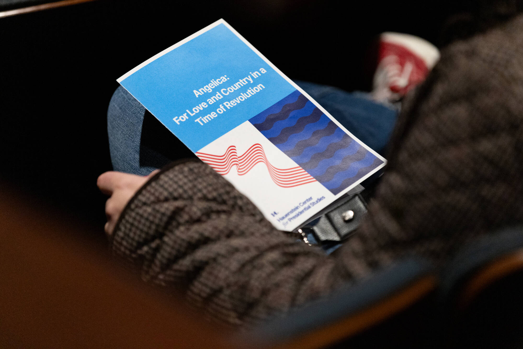 Event program laying in the lap of an attendee